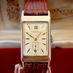 LONGINES ART DECÓ PLATA MACIZA, AÑOS 40 - TEMPPUS: Historia de Longines: 190 Años de Precisión y Elegancia Suiza Longines, una de las marcas relojeras más emblemáticas del mundo, tiene su origen en 1832 en Saint-Imier, Suiza, cuando Auguste Agassiz estableció un taller relojero junto a dos socios bajo el nombre Agassiz & Compagnie. Inicialmente especializados en relojes de bolsillo, ganaron reconocimiento por su precisión milimétrica y acabados artesanales, estableciendo los cimientos de una tradición horológica que perdura hasta hoy. Nacimiento de la marca Longines En 1867, bajo la dirección del sobrino de Agassiz, Ernest Francillon, la compañía experimentó una transformación decisiva. Se construyó la primera fábrica integrada en la zona conocida como Les Longines («los prados largos»), nombre que adoptaría oficialmente la marca. Ese mismo año presentó el revolucionario calibre 20A, su primer movimiento propio, que eliminó la dependencia de subcontratistas gracias a su mecanismo de carga por corona con áncora y escape de palanca. Este hito tecnológico fue galardonado con la medalla de oro en la Exposición Universal de París (1867), consolidando a Longines como sinónimo de innovación suiza. Reconocimiento global y cronometraje deportivo La expansión internacional de Longines se aceleró con logros fundamentales. En 1880 patentó el primer cronógrafo mecánico (calibre 20H), utilizado en competiciones hípicas. Nueve años después registró su emblemático logotipo del reloj de arena alado, convirtiéndose en la marca relojera con la marca registrada más antigua aún activa. El año 1912 marcó otro hito al convertirse en pionera del cronometraje deportivo moderno, cronometrando electrónicamente la Federación Gimnástica Suiza en Basilea, lo que le valió el nombramiento como cronometrador oficial de los Juegos Olímpicos desde 1924. Evolución técnica e iconos de diseño Longines fusionó sofisticación mecánica con elegancia atemporal a través de innovaciones clave. En 1927 lanzó el primer reloj antimagnético (calibre 21.59) para científicos, mientras en 1945 presentó su primer movimiento automático, el calibre 22A, dentro de la colección Elegance. La década de 1950 vio nacer el Conquest, su primera línea resistente al agua con sellado reforzado, símbolo de robustez. Ya en el siglo XXI, relanzó la Master Collection con complicaciones avanzadas como fases lunares y GMT, e introdujo el buceador profesional HydroConquest con 300 metros de resistencia. Legado actual: tradición y tecnología Hoy, Longines mantiene su manufactura original en Saint-Imier, donde produce más de 1.5 millones de relojes anuales. Combina movimientos propios de alta eficiencia como el L888 (72 horas de reserva de marcha) con colecciones que rinden homenaje a su herencia, como la Flagship Heritage (reedición del modelo de 1957) y la línea Spirit inspirada en la aviación. Su compromiso con el deporte perdura como cronometrador oficial de la Federación Ecuestre Internacional, el Abierto de Francia de Tenis y los Juegos Olímpicos, reafirmando 190 años de excelencia en precisión, innovación y elegancia intemporal. TEMPPUS. Todos los derechos reservados.  