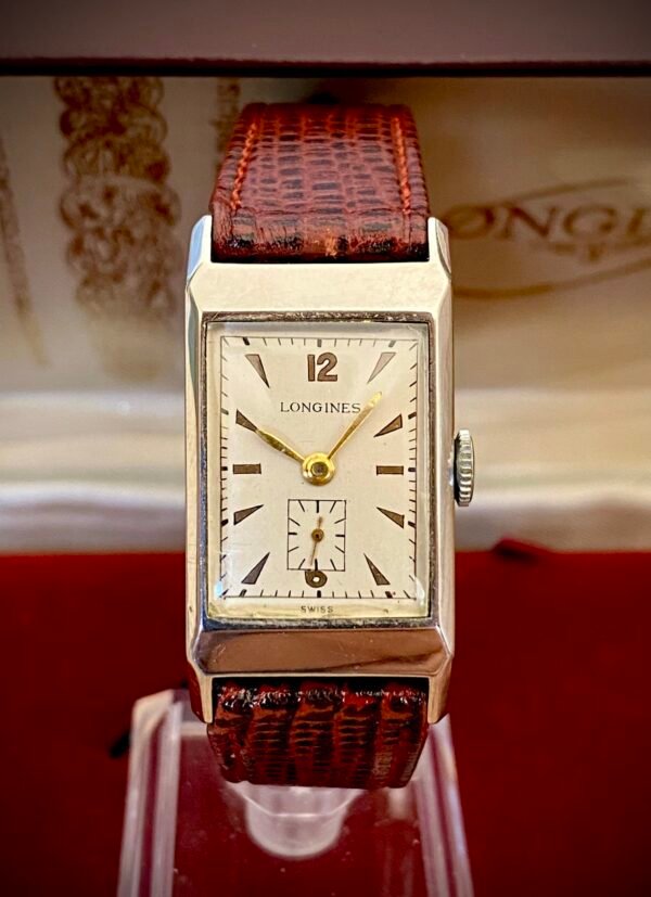 LONGINES ART DECÓ PLATA MACIZA, AÑOS 40 - TEMPPUS: Historia de Longines: 190 Años de Precisión y Elegancia Suiza Longines, una de las marcas relojeras más emblemáticas del mundo, tiene su origen en 1832 en Saint-Imier, Suiza, cuando Auguste Agassiz estableció un taller relojero junto a dos socios bajo el nombre Agassiz & Compagnie. Inicialmente especializados en relojes de bolsillo, ganaron reconocimiento por su precisión milimétrica y acabados artesanales, estableciendo los cimientos de una tradición horológica que perdura hasta hoy. Nacimiento de la marca Longines En 1867, bajo la dirección del sobrino de Agassiz, Ernest Francillon, la compañía experimentó una transformación decisiva. Se construyó la primera fábrica integrada en la zona conocida como Les Longines («los prados largos»), nombre que adoptaría oficialmente la marca. Ese mismo año presentó el revolucionario calibre 20A, su primer movimiento propio, que eliminó la dependencia de subcontratistas gracias a su mecanismo de carga por corona con áncora y escape de palanca. Este hito tecnológico fue galardonado con la medalla de oro en la Exposición Universal de París (1867), consolidando a Longines como sinónimo de innovación suiza. Reconocimiento global y cronometraje deportivo La expansión internacional de Longines se aceleró con logros fundamentales. En 1880 patentó el primer cronógrafo mecánico (calibre 20H), utilizado en competiciones hípicas. Nueve años después registró su emblemático logotipo del reloj de arena alado, convirtiéndose en la marca relojera con la marca registrada más antigua aún activa. El año 1912 marcó otro hito al convertirse en pionera del cronometraje deportivo moderno, cronometrando electrónicamente la Federación Gimnástica Suiza en Basilea, lo que le valió el nombramiento como cronometrador oficial de los Juegos Olímpicos desde 1924. Evolución técnica e iconos de diseño Longines fusionó sofisticación mecánica con elegancia atemporal a través de innovaciones clave. En 1927 lanzó el primer reloj antimagnético (calibre 21.59) para científicos, mientras en 1945 presentó su primer movimiento automático, el calibre 22A, dentro de la colección Elegance. La década de 1950 vio nacer el Conquest, su primera línea resistente al agua con sellado reforzado, símbolo de robustez. Ya en el siglo XXI, relanzó la Master Collection con complicaciones avanzadas como fases lunares y GMT, e introdujo el buceador profesional HydroConquest con 300 metros de resistencia. Legado actual: tradición y tecnología Hoy, Longines mantiene su manufactura original en Saint-Imier, donde produce más de 1.5 millones de relojes anuales. Combina movimientos propios de alta eficiencia como el L888 (72 horas de reserva de marcha) con colecciones que rinden homenaje a su herencia, como la Flagship Heritage (reedición del modelo de 1957) y la línea Spirit inspirada en la aviación. Su compromiso con el deporte perdura como cronometrador oficial de la Federación Ecuestre Internacional, el Abierto de Francia de Tenis y los Juegos Olímpicos, reafirmando 190 años de excelencia en precisión, innovación y elegancia intemporal. TEMPPUS. Todos los derechos reservados.  