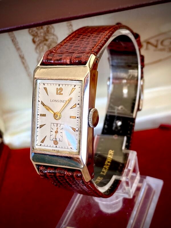 LONGINES ART DECÓ PLATA MACIZA, AÑOS 40 - TEMPPUS: Historia de Longines: 190 Años de Precisión y Elegancia Suiza Longines, una de las marcas relojeras más emblemáticas del mundo, tiene su origen en 1832 en Saint-Imier, Suiza, cuando Auguste Agassiz estableció un taller relojero junto a dos socios bajo el nombre Agassiz & Compagnie. Inicialmente especializados en relojes de bolsillo, ganaron reconocimiento por su precisión milimétrica y acabados artesanales, estableciendo los cimientos de una tradición horológica que perdura hasta hoy. Nacimiento de la marca Longines En 1867, bajo la dirección del sobrino de Agassiz, Ernest Francillon, la compañía experimentó una transformación decisiva. Se construyó la primera fábrica integrada en la zona conocida como Les Longines («los prados largos»), nombre que adoptaría oficialmente la marca. Ese mismo año presentó el revolucionario calibre 20A, su primer movimiento propio, que eliminó la dependencia de subcontratistas gracias a su mecanismo de carga por corona con áncora y escape de palanca. Este hito tecnológico fue galardonado con la medalla de oro en la Exposición Universal de París (1867), consolidando a Longines como sinónimo de innovación suiza. Reconocimiento global y cronometraje deportivo La expansión internacional de Longines se aceleró con logros fundamentales. En 1880 patentó el primer cronógrafo mecánico (calibre 20H), utilizado en competiciones hípicas. Nueve años después registró su emblemático logotipo del reloj de arena alado, convirtiéndose en la marca relojera con la marca registrada más antigua aún activa. El año 1912 marcó otro hito al convertirse en pionera del cronometraje deportivo moderno, cronometrando electrónicamente la Federación Gimnástica Suiza en Basilea, lo que le valió el nombramiento como cronometrador oficial de los Juegos Olímpicos desde 1924. Evolución técnica e iconos de diseño Longines fusionó sofisticación mecánica con elegancia atemporal a través de innovaciones clave. En 1927 lanzó el primer reloj antimagnético (calibre 21.59) para científicos, mientras en 1945 presentó su primer movimiento automático, el calibre 22A, dentro de la colección Elegance. La década de 1950 vio nacer el Conquest, su primera línea resistente al agua con sellado reforzado, símbolo de robustez. Ya en el siglo XXI, relanzó la Master Collection con complicaciones avanzadas como fases lunares y GMT, e introdujo el buceador profesional HydroConquest con 300 metros de resistencia. Legado actual: tradición y tecnología Hoy, Longines mantiene su manufactura original en Saint-Imier, donde produce más de 1.5 millones de relojes anuales. Combina movimientos propios de alta eficiencia como el L888 (72 horas de reserva de marcha) con colecciones que rinden homenaje a su herencia, como la Flagship Heritage (reedición del modelo de 1957) y la línea Spirit inspirada en la aviación. Su compromiso con el deporte perdura como cronometrador oficial de la Federación Ecuestre Internacional, el Abierto de Francia de Tenis y los Juegos Olímpicos, reafirmando 190 años de excelencia en precisión, innovación y elegancia intemporal. TEMPPUS. Todos los derechos reservados.  