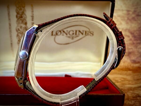 LONGINES ART DECÓ PLATA MACIZA, AÑOS 40 - TEMPPUS: Historia de Longines: 190 Años de Precisión y Elegancia Suiza Longines, una de las marcas relojeras más emblemáticas del mundo, tiene su origen en 1832 en Saint-Imier, Suiza, cuando Auguste Agassiz estableció un taller relojero junto a dos socios bajo el nombre Agassiz & Compagnie. Inicialmente especializados en relojes de bolsillo, ganaron reconocimiento por su precisión milimétrica y acabados artesanales, estableciendo los cimientos de una tradición horológica que perdura hasta hoy. Nacimiento de la marca Longines En 1867, bajo la dirección del sobrino de Agassiz, Ernest Francillon, la compañía experimentó una transformación decisiva. Se construyó la primera fábrica integrada en la zona conocida como Les Longines («los prados largos»), nombre que adoptaría oficialmente la marca. Ese mismo año presentó el revolucionario calibre 20A, su primer movimiento propio, que eliminó la dependencia de subcontratistas gracias a su mecanismo de carga por corona con áncora y escape de palanca. Este hito tecnológico fue galardonado con la medalla de oro en la Exposición Universal de París (1867), consolidando a Longines como sinónimo de innovación suiza. Reconocimiento global y cronometraje deportivo La expansión internacional de Longines se aceleró con logros fundamentales. En 1880 patentó el primer cronógrafo mecánico (calibre 20H), utilizado en competiciones hípicas. Nueve años después registró su emblemático logotipo del reloj de arena alado, convirtiéndose en la marca relojera con la marca registrada más antigua aún activa. El año 1912 marcó otro hito al convertirse en pionera del cronometraje deportivo moderno, cronometrando electrónicamente la Federación Gimnástica Suiza en Basilea, lo que le valió el nombramiento como cronometrador oficial de los Juegos Olímpicos desde 1924. Evolución técnica e iconos de diseño Longines fusionó sofisticación mecánica con elegancia atemporal a través de innovaciones clave. En 1927 lanzó el primer reloj antimagnético (calibre 21.59) para científicos, mientras en 1945 presentó su primer movimiento automático, el calibre 22A, dentro de la colección Elegance. La década de 1950 vio nacer el Conquest, su primera línea resistente al agua con sellado reforzado, símbolo de robustez. Ya en el siglo XXI, relanzó la Master Collection con complicaciones avanzadas como fases lunares y GMT, e introdujo el buceador profesional HydroConquest con 300 metros de resistencia. Legado actual: tradición y tecnología Hoy, Longines mantiene su manufactura original en Saint-Imier, donde produce más de 1.5 millones de relojes anuales. Combina movimientos propios de alta eficiencia como el L888 (72 horas de reserva de marcha) con colecciones que rinden homenaje a su herencia, como la Flagship Heritage (reedición del modelo de 1957) y la línea Spirit inspirada en la aviación. Su compromiso con el deporte perdura como cronometrador oficial de la Federación Ecuestre Internacional, el Abierto de Francia de Tenis y los Juegos Olímpicos, reafirmando 190 años de excelencia en precisión, innovación y elegancia intemporal. TEMPPUS. Todos los derechos reservados.  