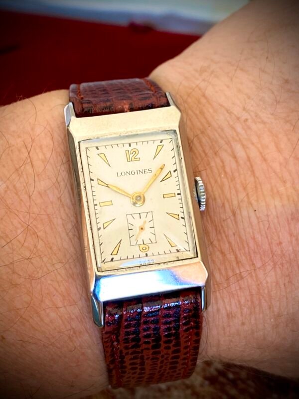 LONGINES ART DECÓ PLATA MACIZA, AÑOS 40 - TEMPPUS: Historia de Longines: 190 Años de Precisión y Elegancia Suiza Longines, una de las marcas relojeras más emblemáticas del mundo, tiene su origen en 1832 en Saint-Imier, Suiza, cuando Auguste Agassiz estableció un taller relojero junto a dos socios bajo el nombre Agassiz & Compagnie. Inicialmente especializados en relojes de bolsillo, ganaron reconocimiento por su precisión milimétrica y acabados artesanales, estableciendo los cimientos de una tradición horológica que perdura hasta hoy. Nacimiento de la marca Longines En 1867, bajo la dirección del sobrino de Agassiz, Ernest Francillon, la compañía experimentó una transformación decisiva. Se construyó la primera fábrica integrada en la zona conocida como Les Longines («los prados largos»), nombre que adoptaría oficialmente la marca. Ese mismo año presentó el revolucionario calibre 20A, su primer movimiento propio, que eliminó la dependencia de subcontratistas gracias a su mecanismo de carga por corona con áncora y escape de palanca. Este hito tecnológico fue galardonado con la medalla de oro en la Exposición Universal de París (1867), consolidando a Longines como sinónimo de innovación suiza. Reconocimiento global y cronometraje deportivo La expansión internacional de Longines se aceleró con logros fundamentales. En 1880 patentó el primer cronógrafo mecánico (calibre 20H), utilizado en competiciones hípicas. Nueve años después registró su emblemático logotipo del reloj de arena alado, convirtiéndose en la marca relojera con la marca registrada más antigua aún activa. El año 1912 marcó otro hito al convertirse en pionera del cronometraje deportivo moderno, cronometrando electrónicamente la Federación Gimnástica Suiza en Basilea, lo que le valió el nombramiento como cronometrador oficial de los Juegos Olímpicos desde 1924. Evolución técnica e iconos de diseño Longines fusionó sofisticación mecánica con elegancia atemporal a través de innovaciones clave. En 1927 lanzó el primer reloj antimagnético (calibre 21.59) para científicos, mientras en 1945 presentó su primer movimiento automático, el calibre 22A, dentro de la colección Elegance. La década de 1950 vio nacer el Conquest, su primera línea resistente al agua con sellado reforzado, símbolo de robustez. Ya en el siglo XXI, relanzó la Master Collection con complicaciones avanzadas como fases lunares y GMT, e introdujo el buceador profesional HydroConquest con 300 metros de resistencia. Legado actual: tradición y tecnología Hoy, Longines mantiene su manufactura original en Saint-Imier, donde produce más de 1.5 millones de relojes anuales. Combina movimientos propios de alta eficiencia como el L888 (72 horas de reserva de marcha) con colecciones que rinden homenaje a su herencia, como la Flagship Heritage (reedición del modelo de 1957) y la línea Spirit inspirada en la aviación. Su compromiso con el deporte perdura como cronometrador oficial de la Federación Ecuestre Internacional, el Abierto de Francia de Tenis y los Juegos Olímpicos, reafirmando 190 años de excelencia en precisión, innovación y elegancia intemporal. TEMPPUS. Todos los derechos reservados.  