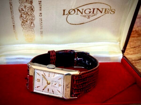 LONGINES ART DECÓ PLATA MACIZA, AÑOS 40 - TEMPPUS: Historia de Longines: 190 Años de Precisión y Elegancia Suiza Longines, una de las marcas relojeras más emblemáticas del mundo, tiene su origen en 1832 en Saint-Imier, Suiza, cuando Auguste Agassiz estableció un taller relojero junto a dos socios bajo el nombre Agassiz & Compagnie. Inicialmente especializados en relojes de bolsillo, ganaron reconocimiento por su precisión milimétrica y acabados artesanales, estableciendo los cimientos de una tradición horológica que perdura hasta hoy. Nacimiento de la marca Longines En 1867, bajo la dirección del sobrino de Agassiz, Ernest Francillon, la compañía experimentó una transformación decisiva. Se construyó la primera fábrica integrada en la zona conocida como Les Longines («los prados largos»), nombre que adoptaría oficialmente la marca. Ese mismo año presentó el revolucionario calibre 20A, su primer movimiento propio, que eliminó la dependencia de subcontratistas gracias a su mecanismo de carga por corona con áncora y escape de palanca. Este hito tecnológico fue galardonado con la medalla de oro en la Exposición Universal de París (1867), consolidando a Longines como sinónimo de innovación suiza. Reconocimiento global y cronometraje deportivo La expansión internacional de Longines se aceleró con logros fundamentales. En 1880 patentó el primer cronógrafo mecánico (calibre 20H), utilizado en competiciones hípicas. Nueve años después registró su emblemático logotipo del reloj de arena alado, convirtiéndose en la marca relojera con la marca registrada más antigua aún activa. El año 1912 marcó otro hito al convertirse en pionera del cronometraje deportivo moderno, cronometrando electrónicamente la Federación Gimnástica Suiza en Basilea, lo que le valió el nombramiento como cronometrador oficial de los Juegos Olímpicos desde 1924. Evolución técnica e iconos de diseño Longines fusionó sofisticación mecánica con elegancia atemporal a través de innovaciones clave. En 1927 lanzó el primer reloj antimagnético (calibre 21.59) para científicos, mientras en 1945 presentó su primer movimiento automático, el calibre 22A, dentro de la colección Elegance. La década de 1950 vio nacer el Conquest, su primera línea resistente al agua con sellado reforzado, símbolo de robustez. Ya en el siglo XXI, relanzó la Master Collection con complicaciones avanzadas como fases lunares y GMT, e introdujo el buceador profesional HydroConquest con 300 metros de resistencia. Legado actual: tradición y tecnología Hoy, Longines mantiene su manufactura original en Saint-Imier, donde produce más de 1.5 millones de relojes anuales. Combina movimientos propios de alta eficiencia como el L888 (72 horas de reserva de marcha) con colecciones que rinden homenaje a su herencia, como la Flagship Heritage (reedición del modelo de 1957) y la línea Spirit inspirada en la aviación. Su compromiso con el deporte perdura como cronometrador oficial de la Federación Ecuestre Internacional, el Abierto de Francia de Tenis y los Juegos Olímpicos, reafirmando 190 años de excelencia en precisión, innovación y elegancia intemporal. TEMPPUS. Todos los derechos reservados.  